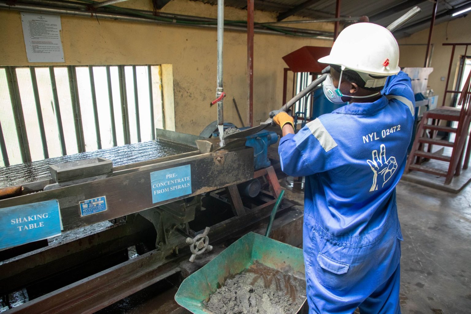 Trabalhador usando equipamento de processamento de minério em uma instalação industrial.