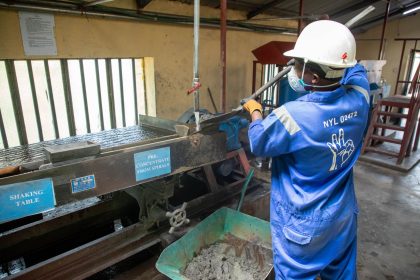 Trabalhador usando equipamento de processamento de minério em uma instalação industrial.