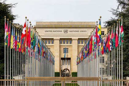 Edifício do escritório da ONU em Genebra cercado por bandeiras de diversos países.