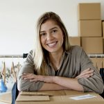 Microempreendedora organiza pedidos e roupas em seu espaço de vendas.