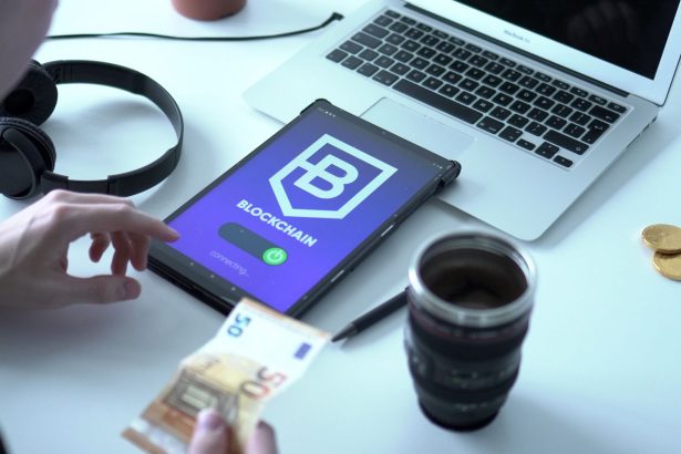 Tablet exibindo uma transação digital ao lado de um laptop e cédulas de euro.